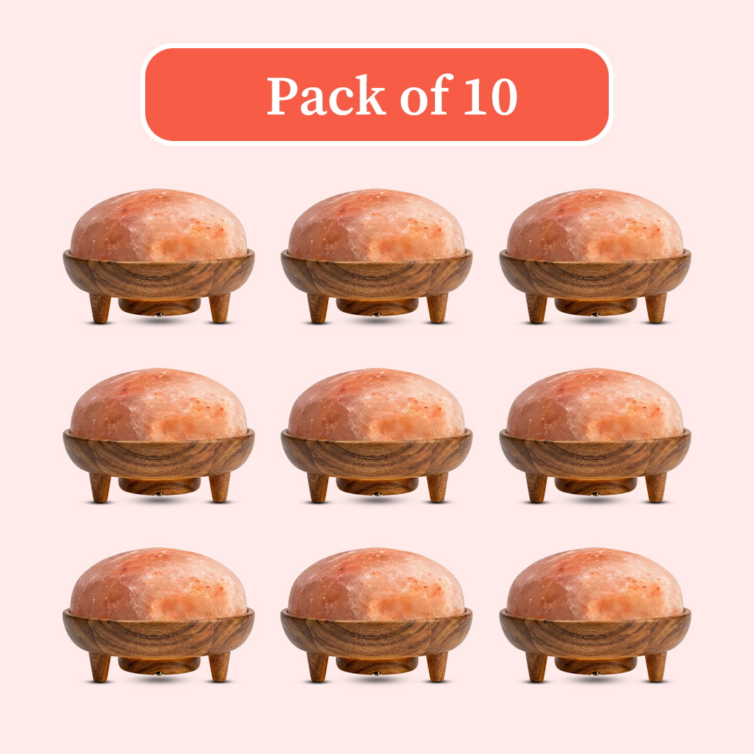 Pack of 10 dome-shaped pink salt lamps with carved wooden bases and small legs, arranged in a 3x3 grid on a pale pink background with an orange label reading 'Pack of 10'.
