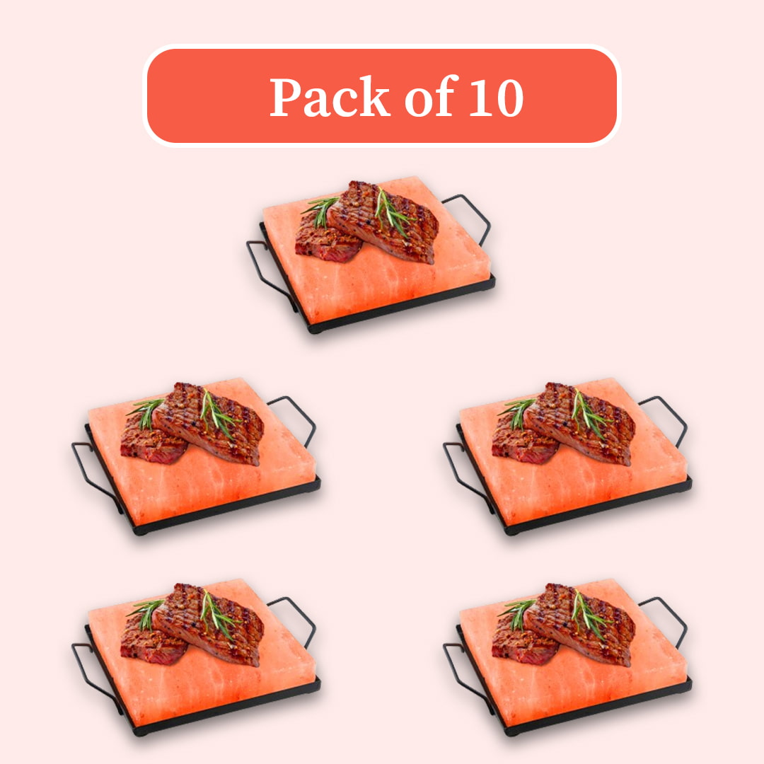 Pack of 10 salt stone grills, featuring five illustrated views of a rectangular pink salt block with a black metal base and handles, topped with grilled meat and rosemary, on a pale pink background with a red-orange 'Pack of 10' label.